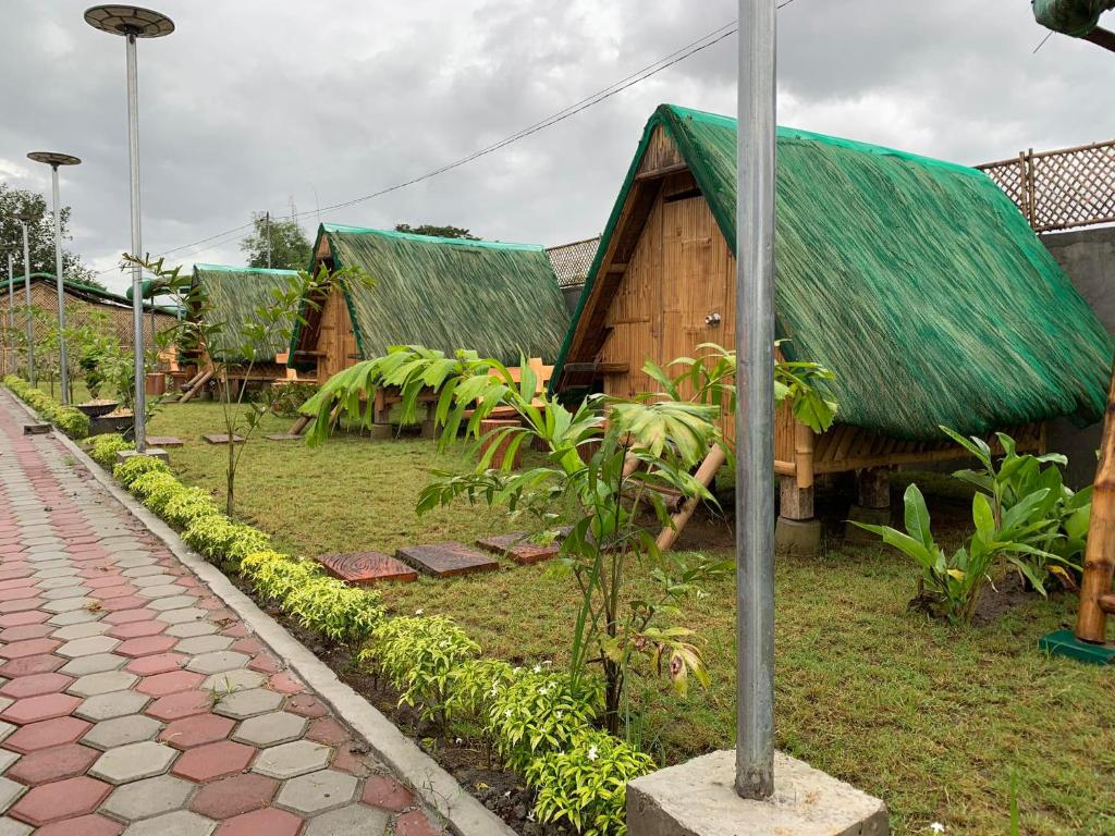 een huis met een groen dak en een stoep bij Unlimited Pax Bale Kubo-inspired Accommodation in Tarlac