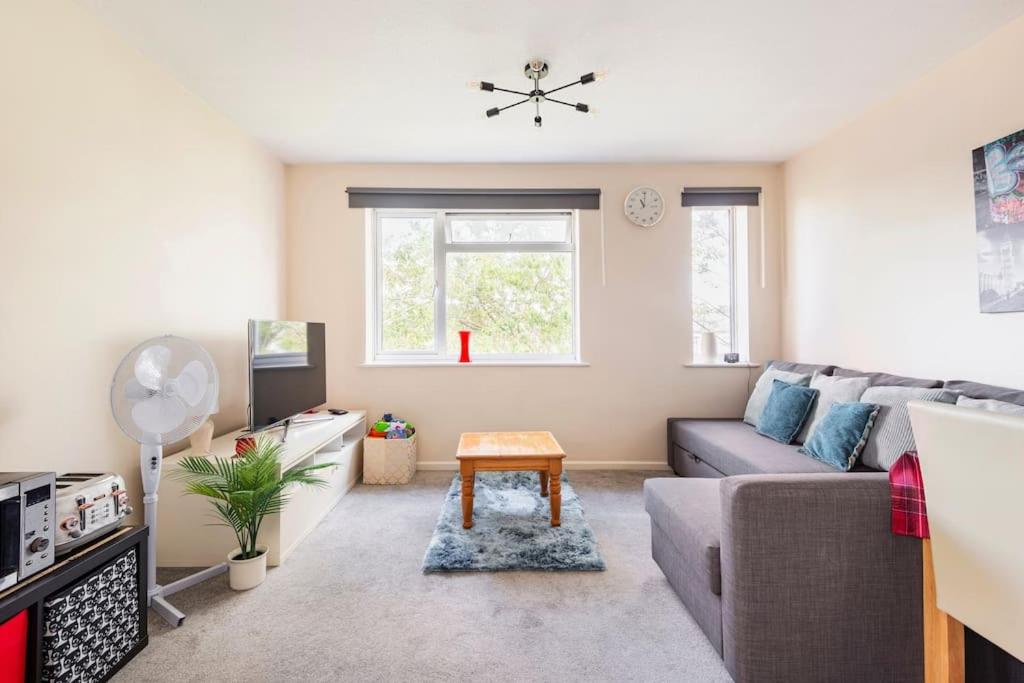 uma sala de estar com um sofá e uma mesa em Charming Entire 2-Bedroom House in Milton Keynes em Milton Keynes