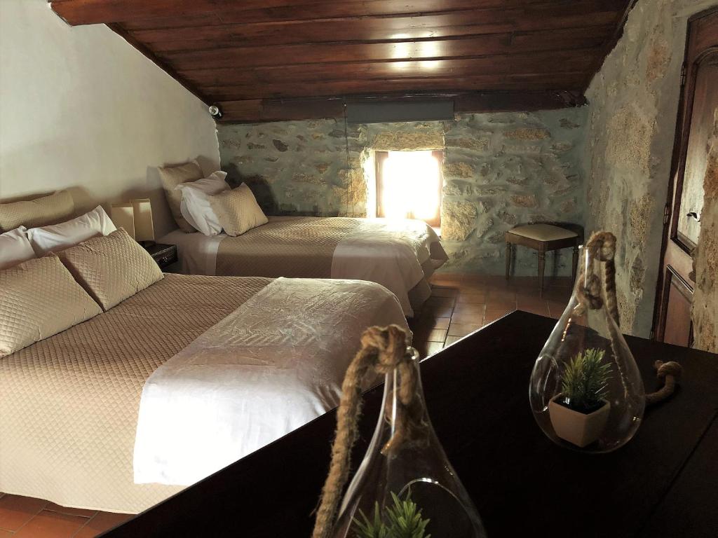 Un dormitorio con dos camas y una ventana. en Casa do Barrosinho, en Penedones