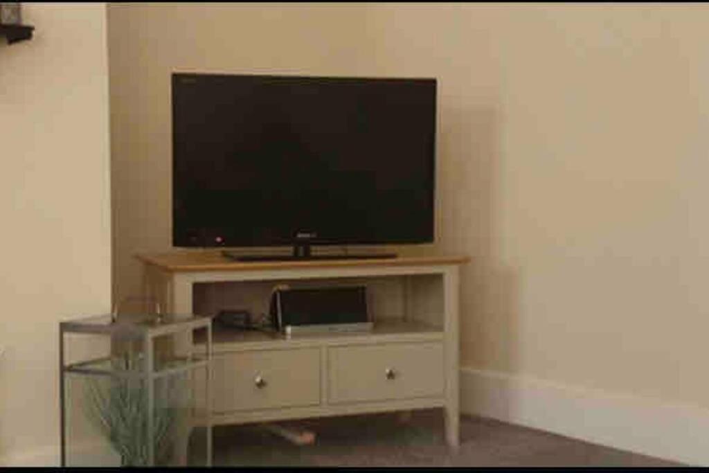 a flat screen tv sitting on top of a entertainment center at Newly Renovated Flat with Free Parking in Walker Gate