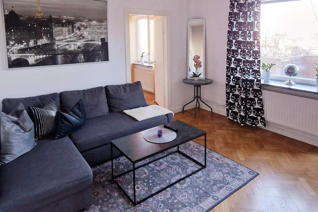 Mysigt lägenhet i Stockholm City في ستوكهولم: غرفة معيشة مع أريكة وطاولة