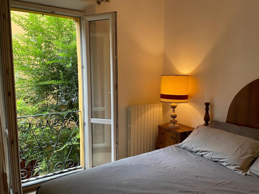 um quarto com uma cama e uma grande janela em Residenza Santo Stefano 95 - Santo Stefano apartment em Bolonha
