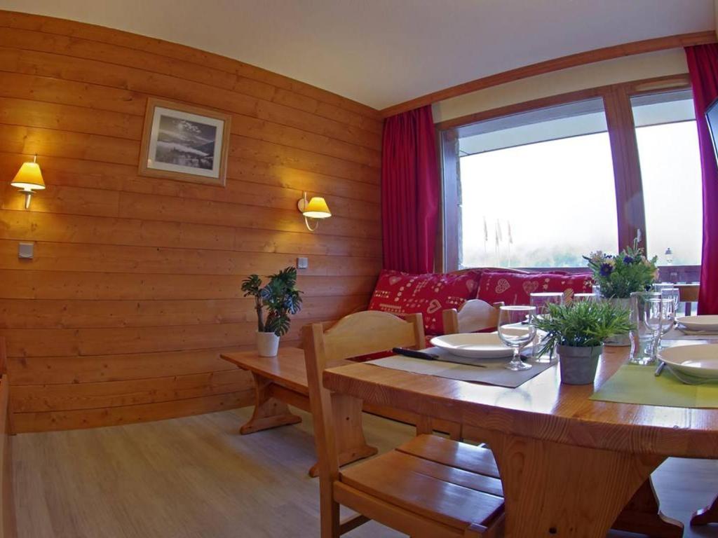 a dining room with a table and a red couch at Appartement Valmorel, 2 pièces, 5 personnes - FR-1-291-697 in Valmorel