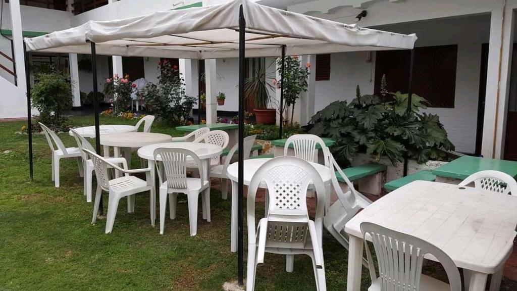 eine Gruppe von Tischen und Stühlen unter einem Schirm in der Unterkunft Hotel 20 de Junio in Mina Clavero