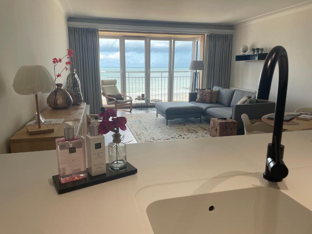 een woonkamer met een bank en een woonkamer met bij Appartement Belle Mer - Adults Only in Middelkerke