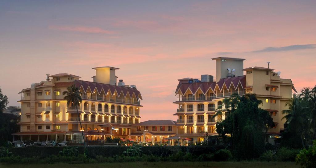 a hotel with two large buildings at dusk at Acron Candolim Regina in Candolim