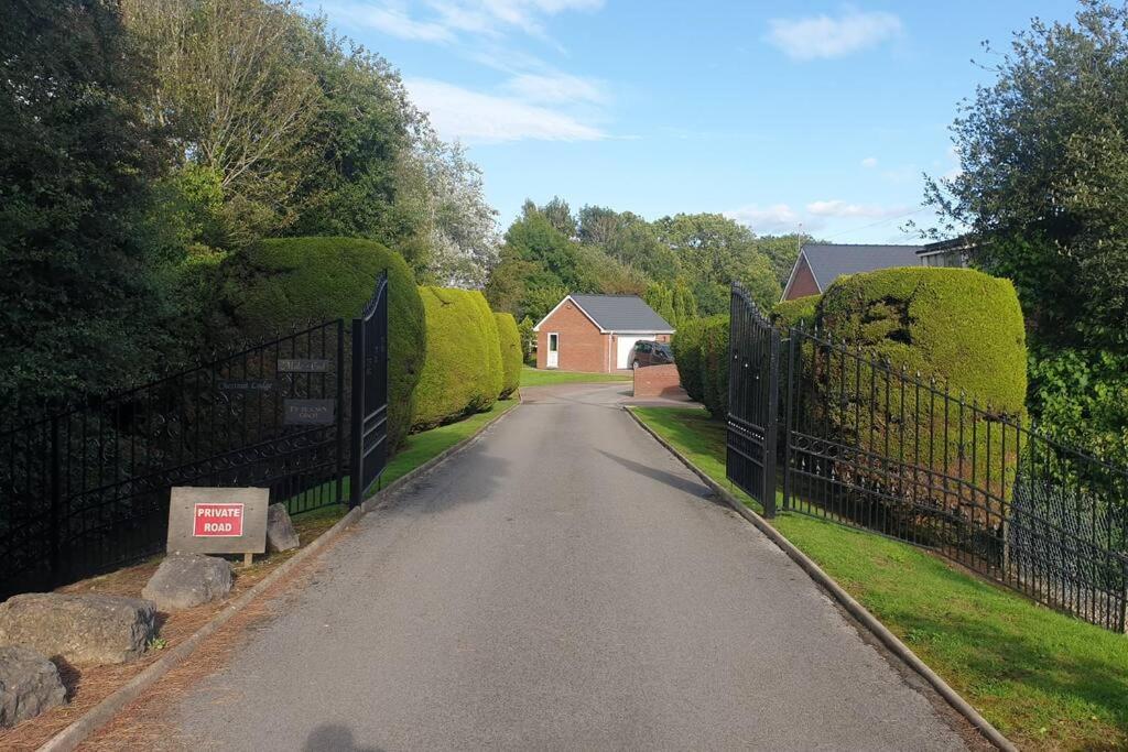 a road with a fence and a house in the background at Chestnut Lodge Annex in Bridgend