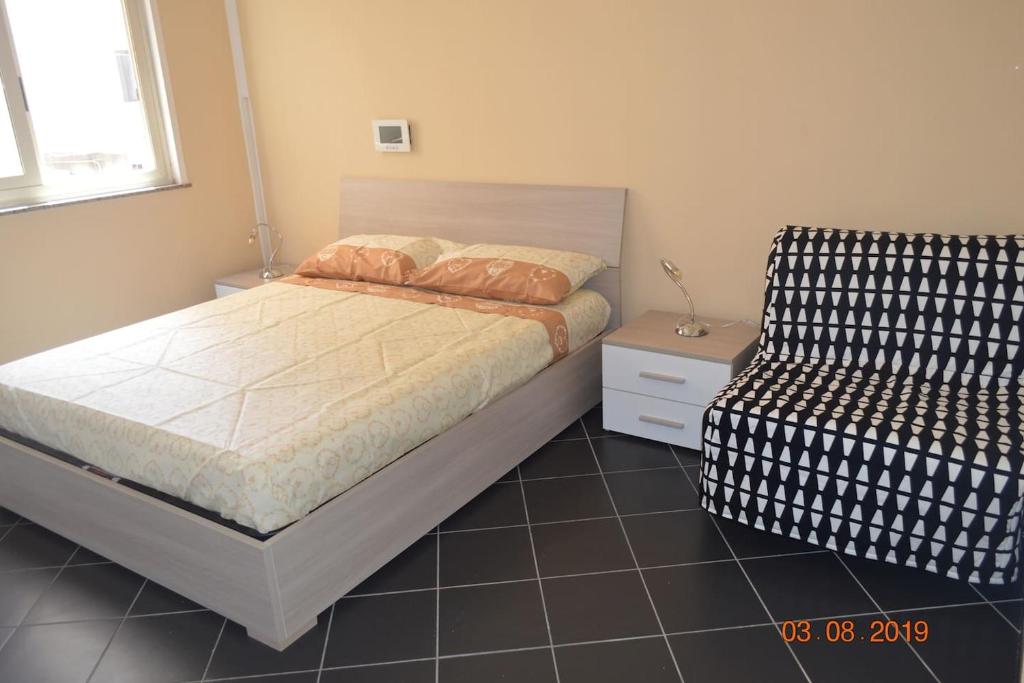ein Schlafzimmer mit einem Bett und einem Stuhl darin in der Unterkunft il veliero di naxos in Giardini-Naxos