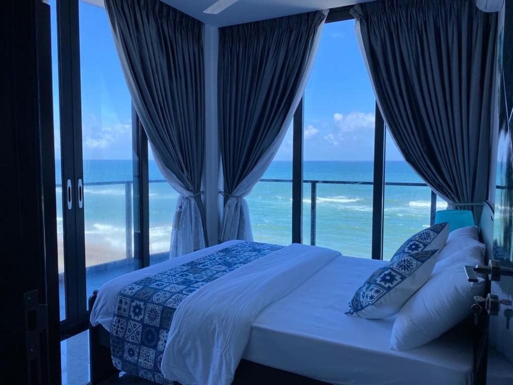 a bedroom with a bed with a view of the ocean at MercuryFM 105 House Colombo 3 - Schofield pl 3-2 in Colombo