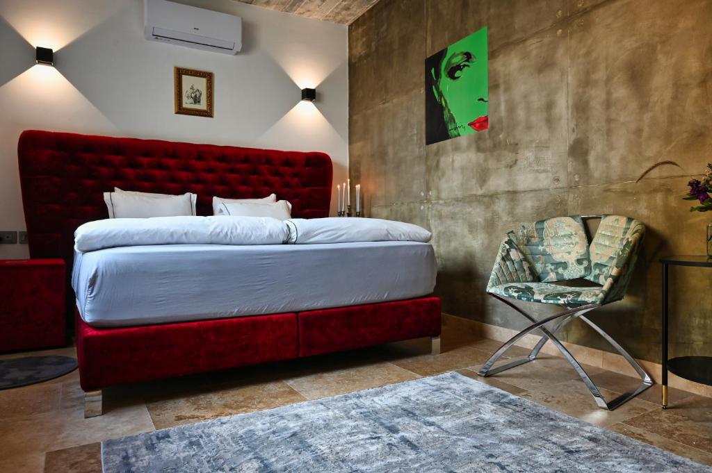 a bedroom with a red bed and a chair at Cittadella Suite in Victoria