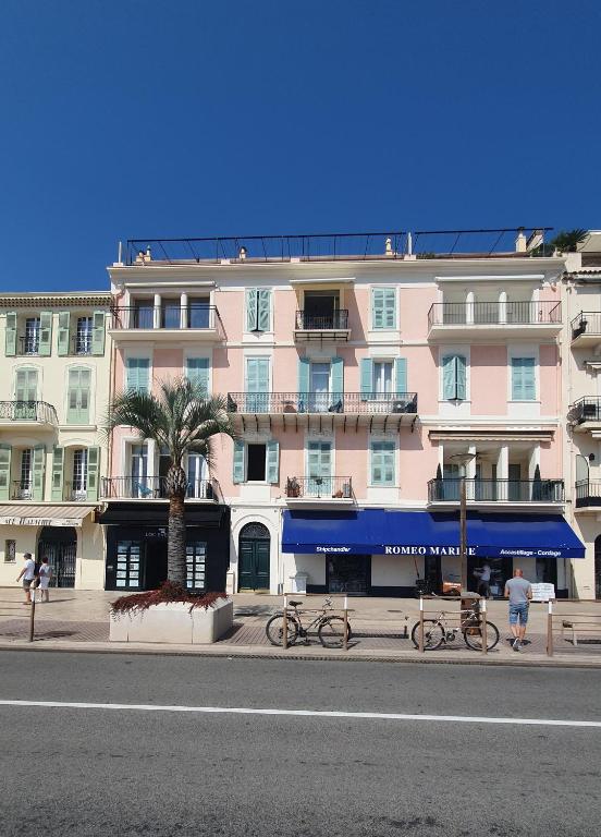 un grand bâtiment rose sur le côté d'une rue dans l'établissement Bel Appartement Typique proche du Palais et Plages, à Cannes