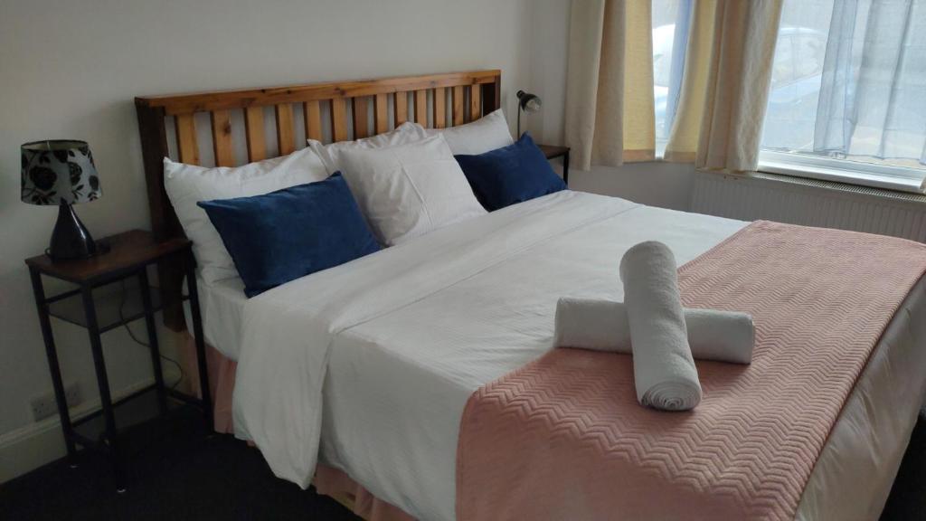 a bedroom with a large white bed with blue pillows at Fair Oak Self-Catering Accomodation in Sandown