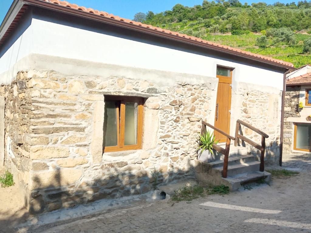 une maison en pierre avec des portes jaunes et un escalier dans l'établissement O cantinho da Laura, à Lamego