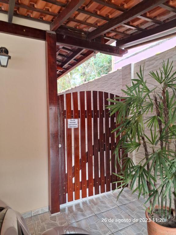 une terrasse couverte avec une porte en bois et une plante dans l'établissement Casa em Ilhabela, à Ilhabela
