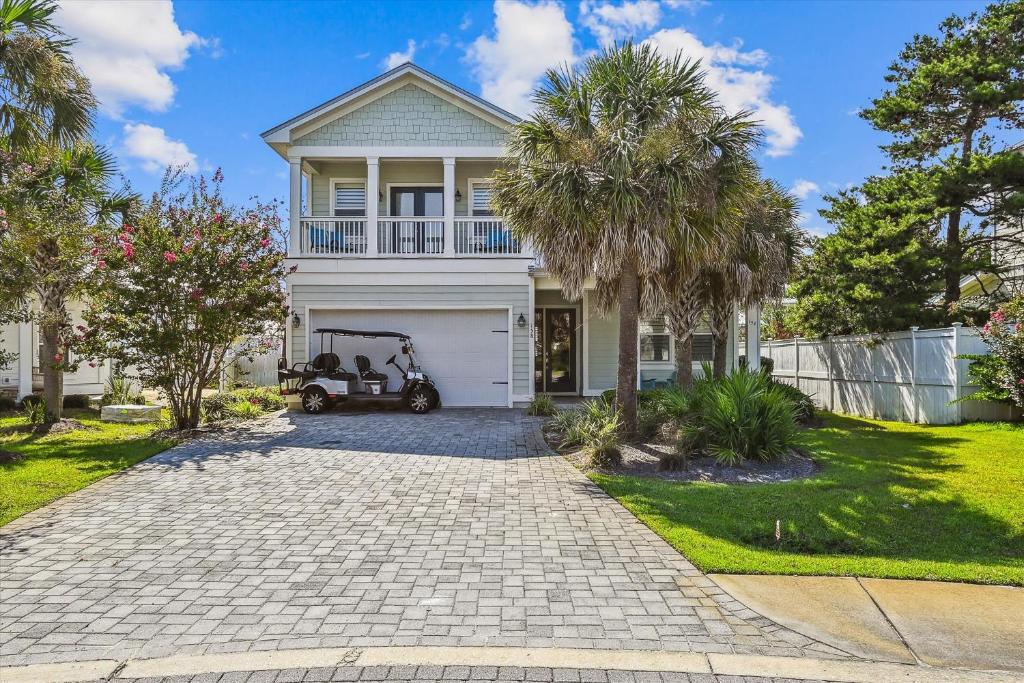 een huis met een witte garage en palmbomen bij Resting Beach Place home in Destin