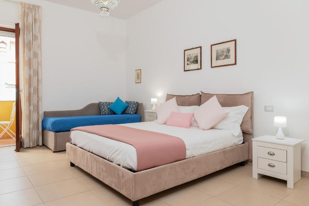 um quarto com uma cama grande e um sofá em Kalos em Sorrento