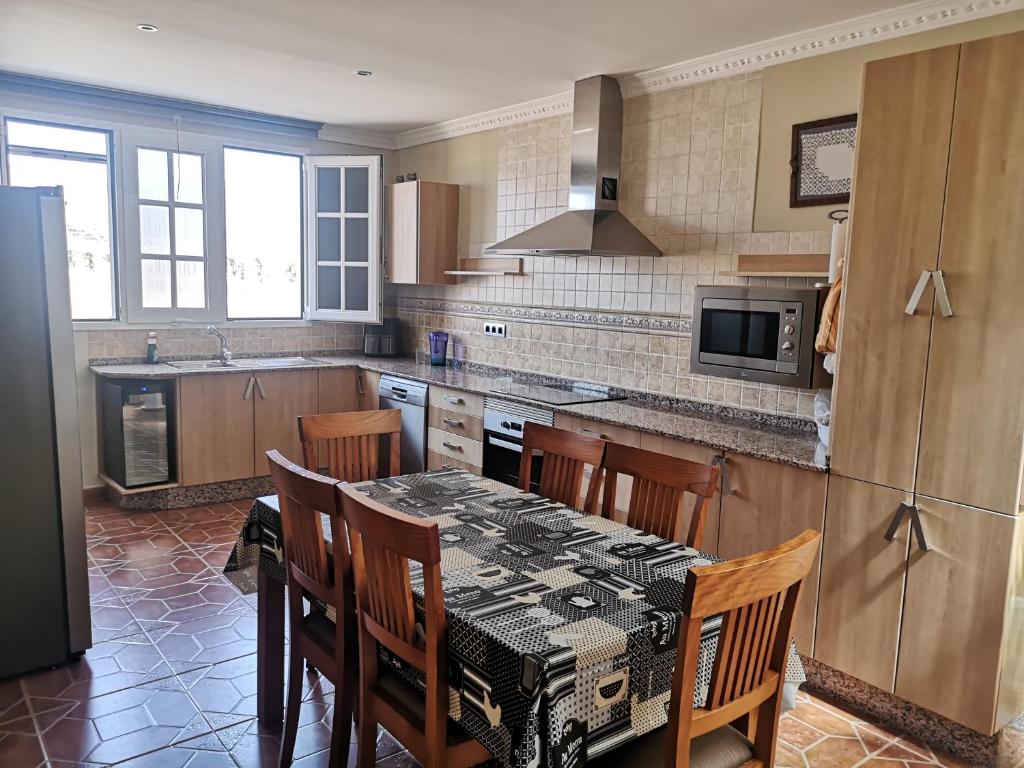 een keuken met een tafel en stoelen bij La casa de Rei in Sardina