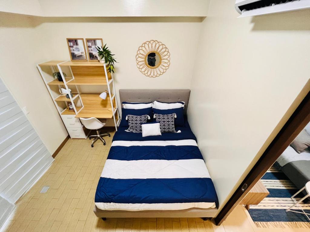 a bedroom with a bed with blue and white pillows at 4 Majestic View in Iloilo City