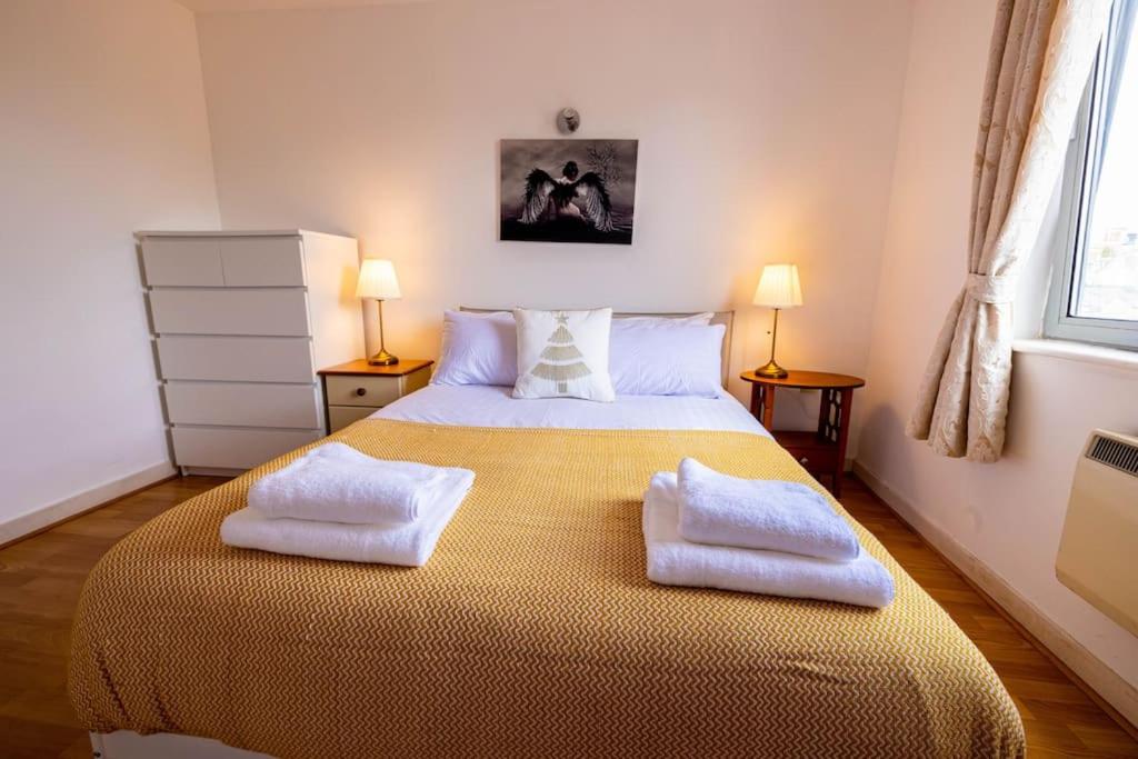 a bedroom with a large bed with two towels on it at IGM 2beds Property in London
