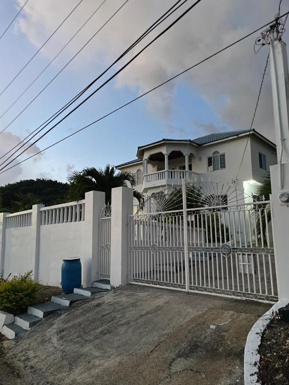 a white fence in front of a house at The Retreat in Lyssons