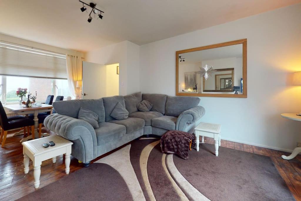 a living room with a couch and a mirror at Spacious one bedroom flat in West Hoathley