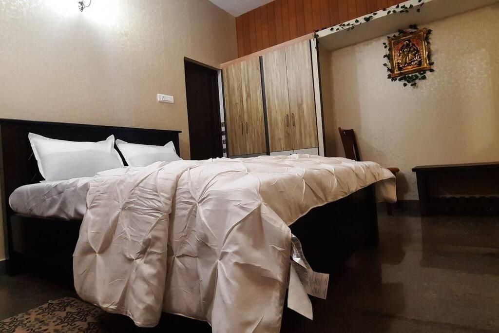 蒂魯帕蒂的住宿－Tejovrishananda Luxury Stays，卧室配有一张带白色棉被的大床