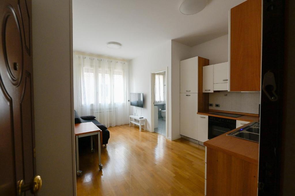 a kitchen with white cabinets and a wooden floor at TulipHouse da Davide in Bologna
