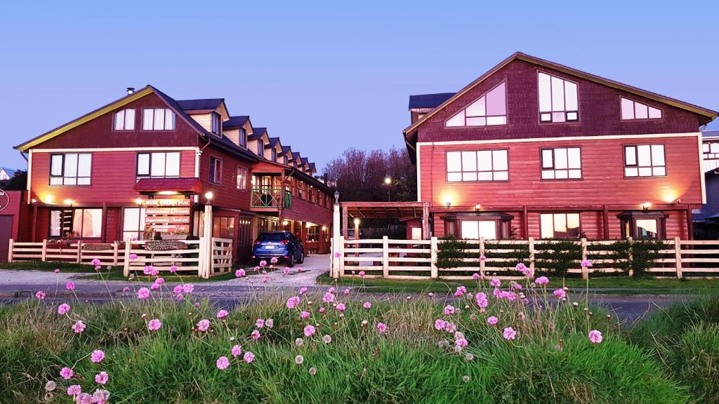 une grande maison avec des fleurs roses devant elle dans l'établissement Hostal Vista al Mar hct, à Ancud