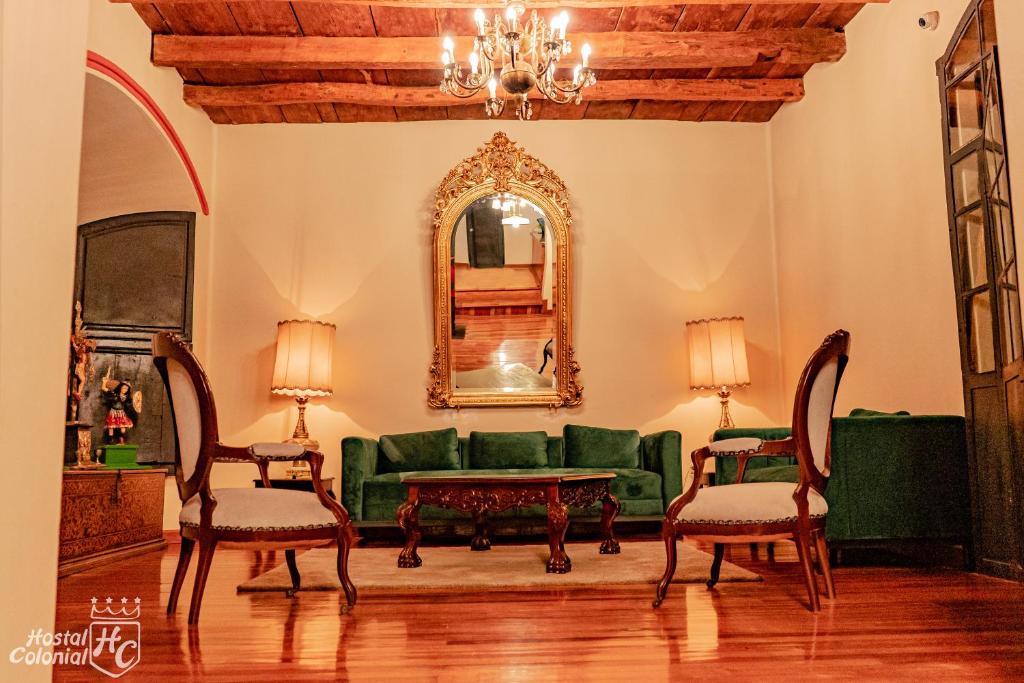 a living room with a green couch and a mirror at Hostal Colonial Potosi in Potosí