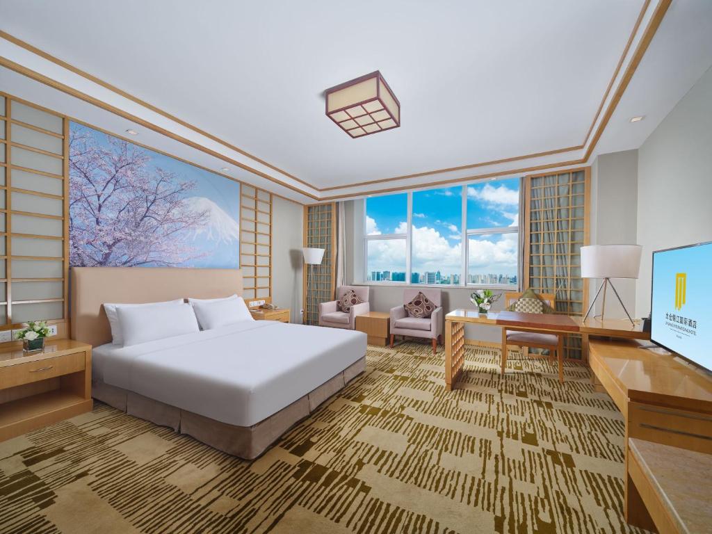 a hotel room with a bed and a desk at Jin Jiang International Hotel Taicang in Taicang