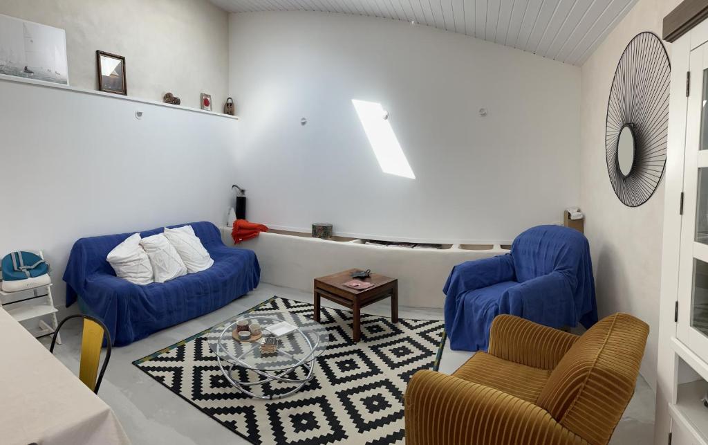 a living room with two blue chairs and a table at LE CLOS DE FLO 17 in Saint-Rogatien