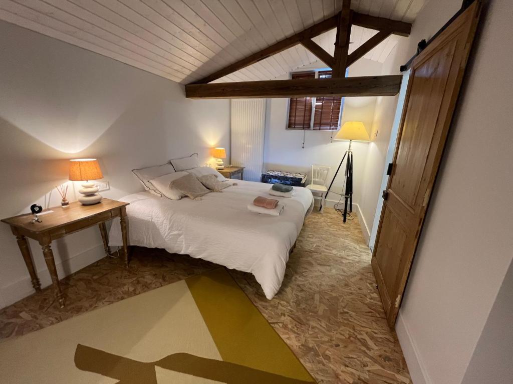a bedroom with a bed and a table and lamps at LE CLOS DE FLO 17 in Saint-Rogatien