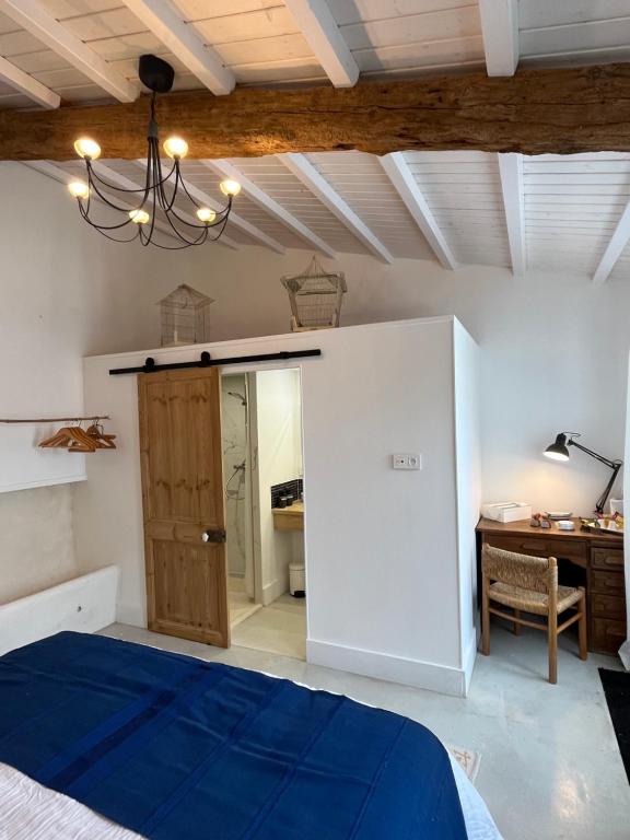 a bedroom with a blue bed and a desk at LE CLOS DE FLO 17 in Saint-Rogatien
