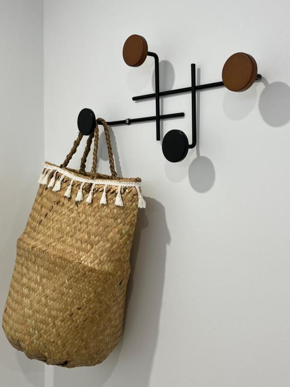 a rattan purse hanging on a wall with a sign at LE CLOS DE FLO 17 in Saint-Rogatien