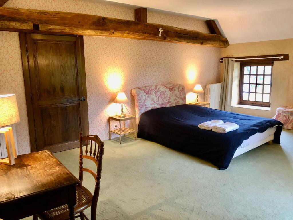 a bedroom with a bed and a table and a desk at Chambre d'hôte à la Gilardière 