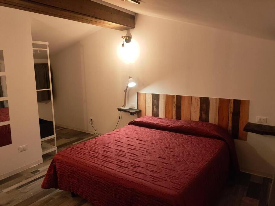 una camera con un letto rosso e una coperta rossa di casa vacanze Villanova - 4 posti letto a Villanova