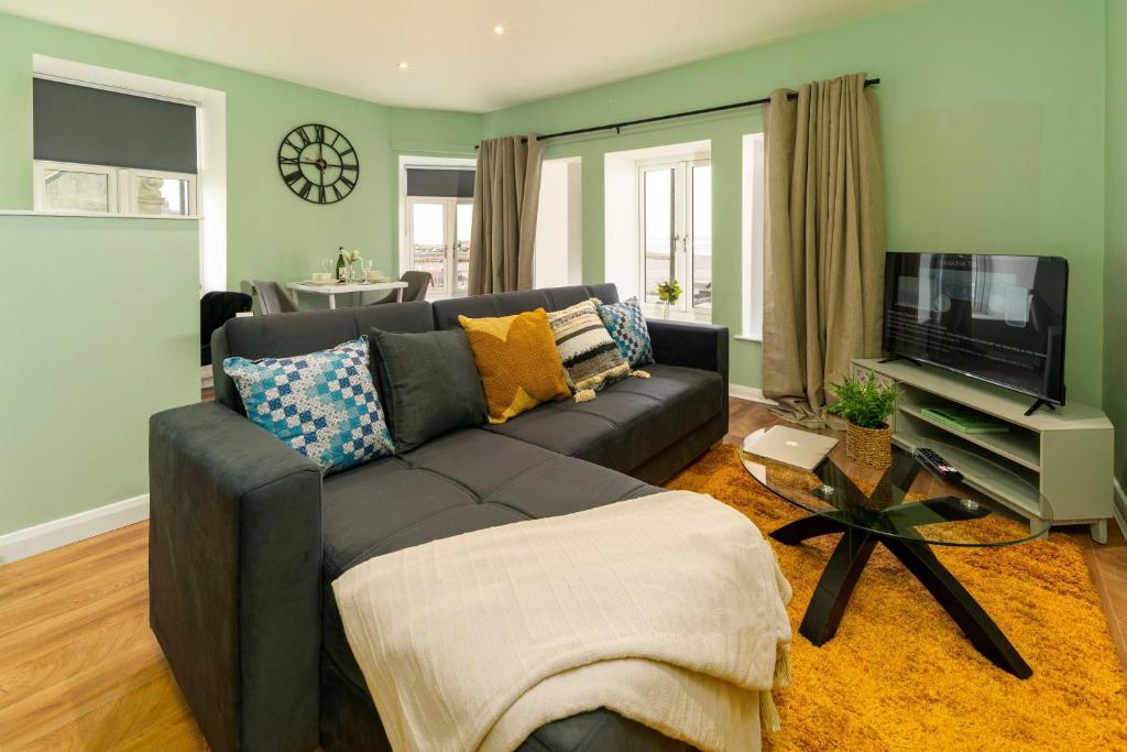 a living room with a couch and a flat screen tv at Clock Tower Retreat - Sea View Apartments in Morecambe in Morecambe