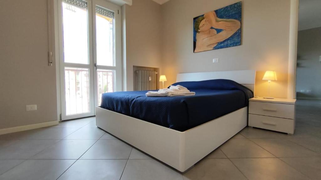 una camera da letto con un letto con lenzuola blu e una finestra di CASA MATISSE a Parma