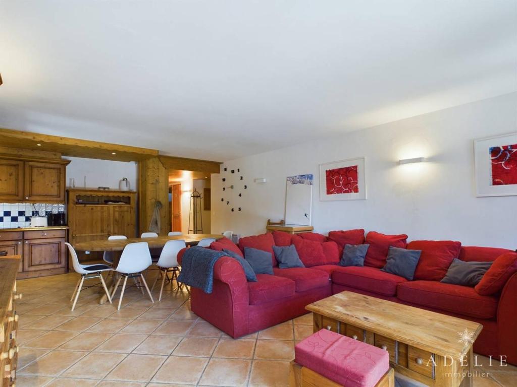 un salon avec un canapé rouge et une cuisine dans l'établissement Superbe 4 pièces à Montvalezan avec terrasse SE, proche pistes et commerces, parking inclus - FR-1-398-534, à La Rosière