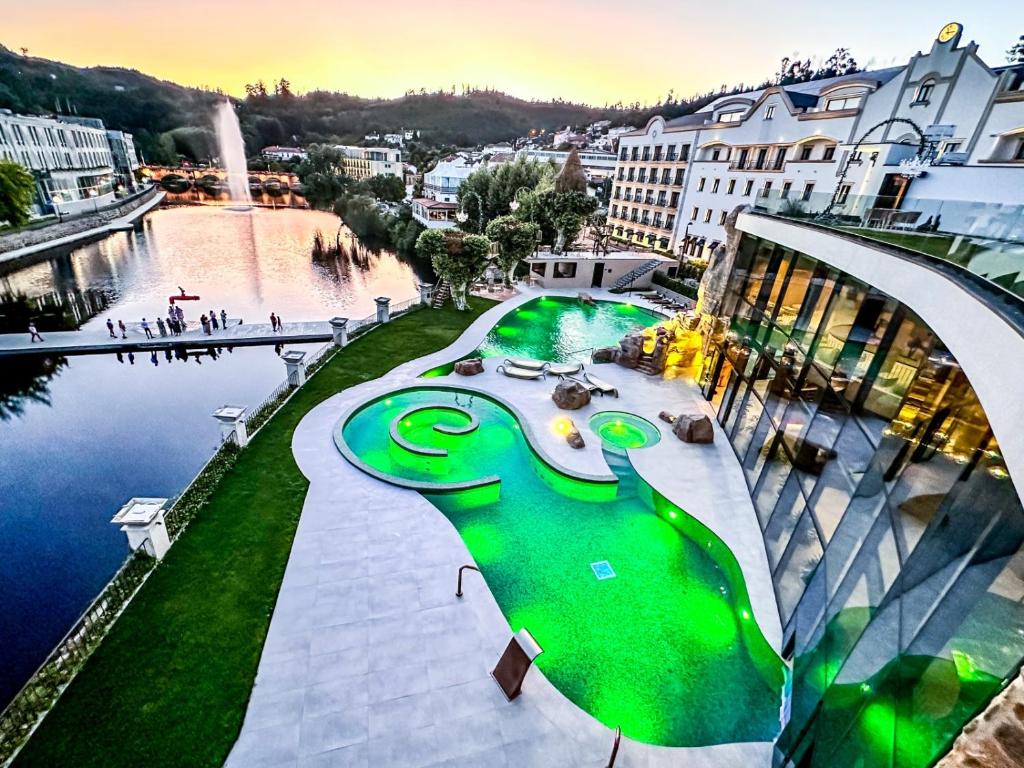 uma vista para uma cidade com uma piscina verde em Grande Hotel Thermas Nature & SPA nas Termas de São Pedro do Sul