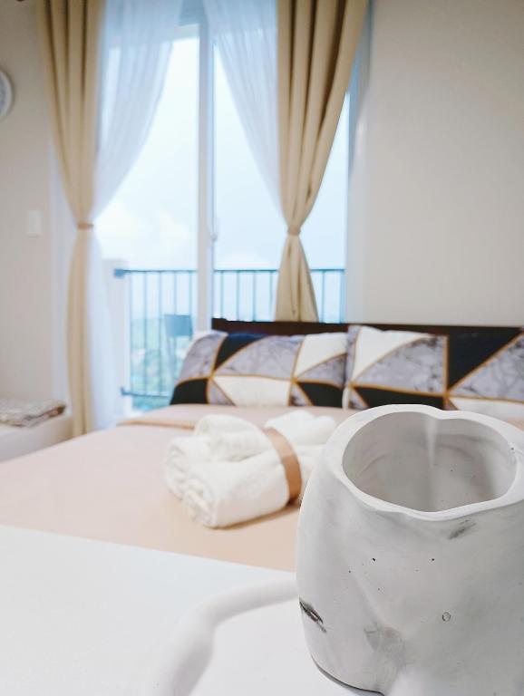 a white vase sitting on top of a bed at Z's Place in Suba
