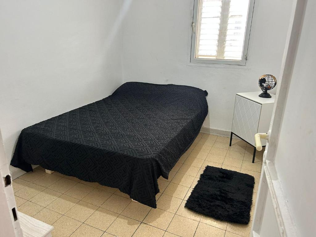 1 dormitorio con cama negra y ventana en LUXURY privet room near Tel Aviv, en Petaj Tikva