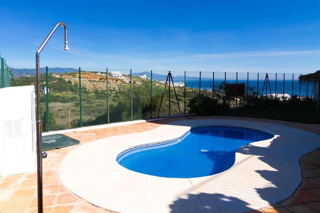 a swimming pool with a view of the ocean at Estrella de Bahia Casares in Casares