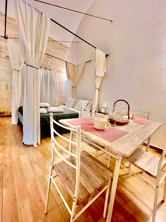 ein Esszimmer mit einem Tisch, Stühlen und einem Bett in der Unterkunft Casa Vacanza L'Alchimista Mottola in Mottola