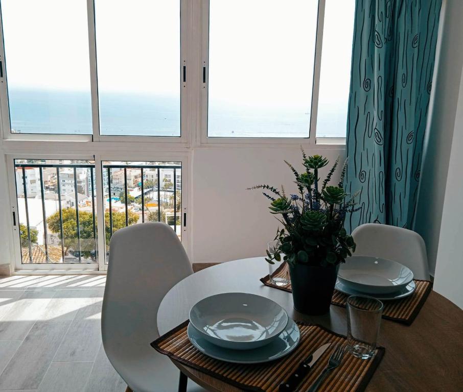 uma mesa de jantar e cadeiras com vista para o oceano em Blue Sky Apartment em Torremolinos
