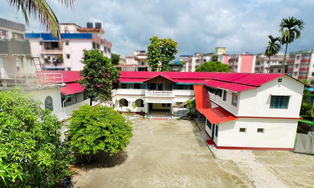 a house with a red roof in a city at Levi Home Guest House & Retreat Centre in Siliguri