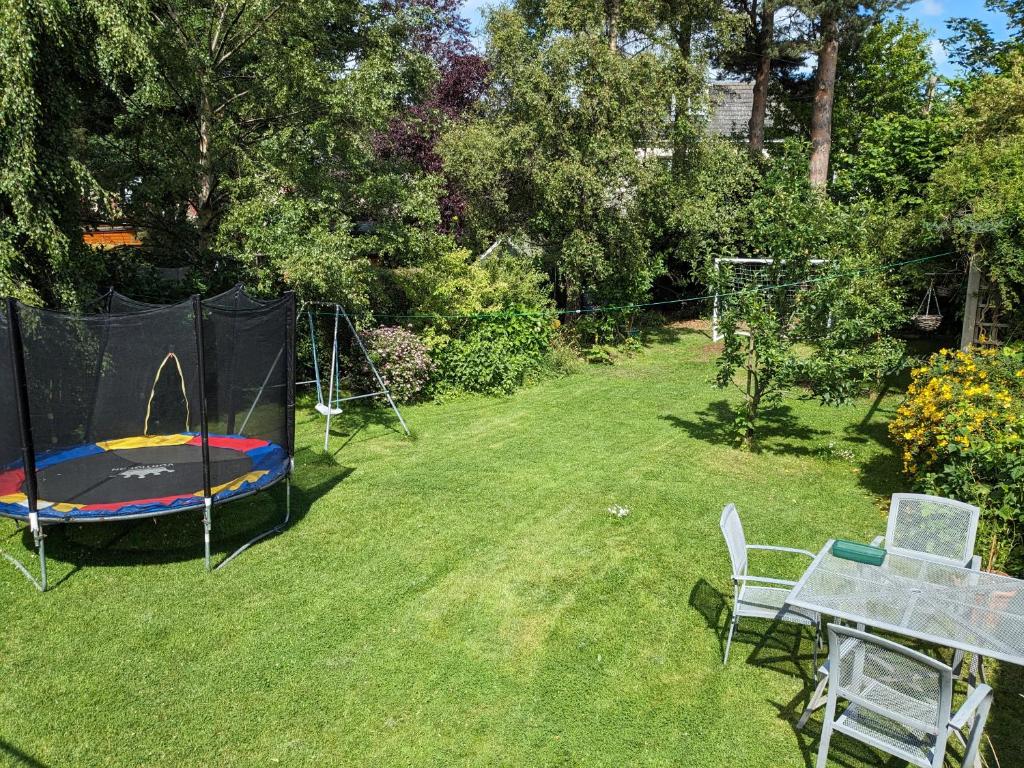 a backyard with a trampoline and a trampoline at Private room with terrace and free parking in Edinburgh