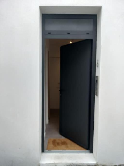 a doorway to a hallway with a black door at Beau Duplex Neuf Calme Lumineux 45m2 en plein COEUR de la station à 100m du port sur book ing &amp; rbnb in Bénodet