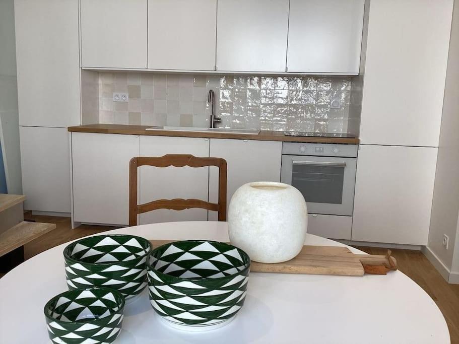 a kitchen with a table with a vase on it at Beau Duplex Neuf Calme Lumineux 45m2 en plein COEUR de la station à 100m du port sur book ing &amp; rbnb in Bénodet