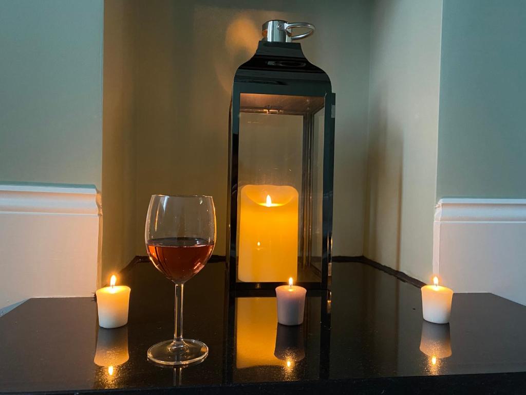 a bottle of wine and a glass and candles on a table at Hidden in plain sight in Kent